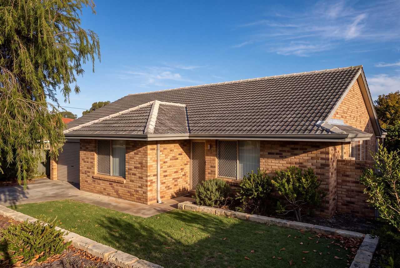 Single-storey Perth brick home with a hipped charcoal concrete-tile roof, showing the ridge, hips, a valley and gutters